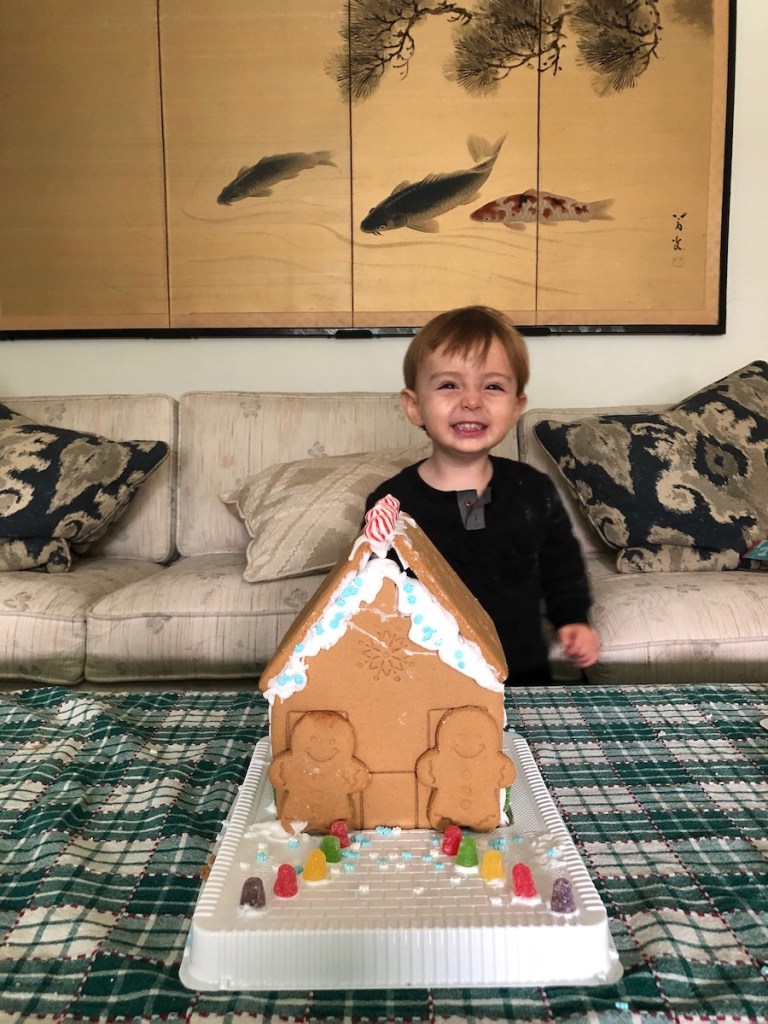 toddler smiling with gingerbread house